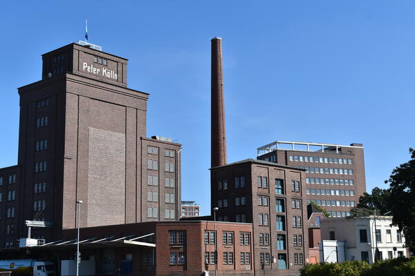 Das turmartige Silo mit aufgesetzter Laterne aus rotem Backstein ist  weit sichtbar zwischen den Produktionsgebäude.