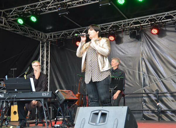 Die Sängerin singt in ein Mikrofon auf der Bühne des plattdeutschen Festivals.