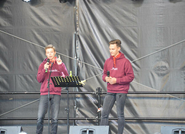 Zwei jugendliche Musiker rappen auf der Bühne plattdeutschen Festivals.