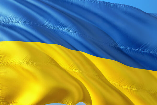 Die Ukrainische Flagge weht vor blauem Himmel.